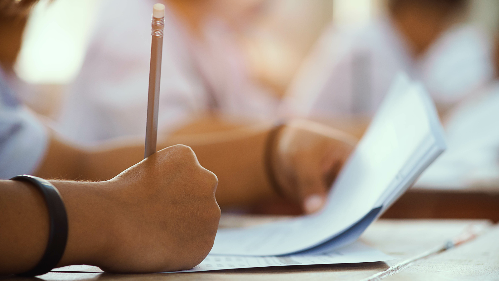 Student writing on exam papers